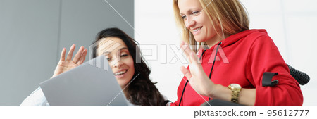 Women greeting family via online video call using laptop, woman visit friend in wheelchair Women greeting family via online video call using laptop, woman visit friend in wheelchair 95612777