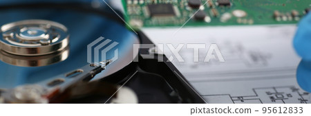 Male technician hold computer details, try to fix or collect device, dvd disc Male technician hold computer details, try to fix or collect device, dvd disc 95612833