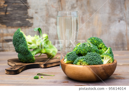 Ready to eat fresh raw broccoli is divided into inflorescences in a wooden plate and on a cutting board on a wooden table. Healthy lifestyle, nutrition and zero waste concept Ready to eat fresh raw broccoli is divided into inflorescences in a wooden plate and on a cutting board on a wooden table. Healthy lifestyle, nutrition and zero waste concept 95614014