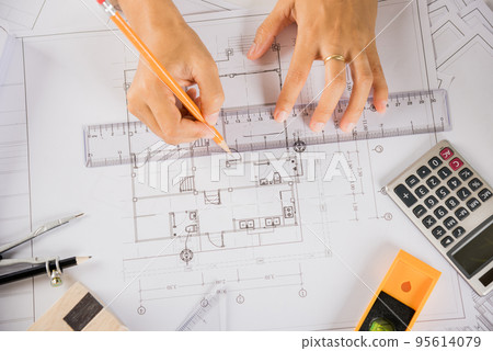 Architect drawing with ruler on house plan blueprint paper for repair tools on table Architect drawing with ruler on house plan blueprint paper for repair tools on table 95614079