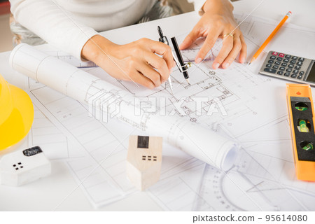 Architect drawing with divider compass on house plan blueprint paper 95614080