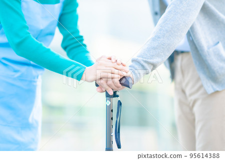 Care manager's hands supporting seniors Faceless 95614388