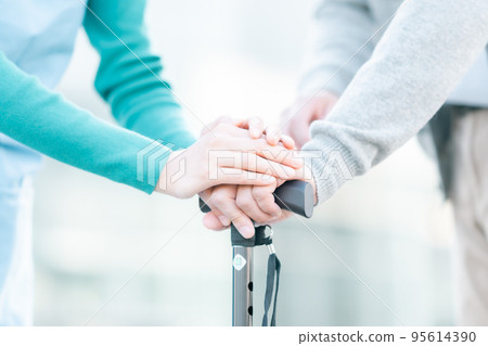 Care manager's hands supporting seniors Faceless 95614390