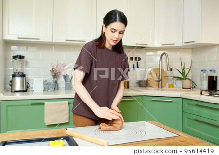 Young woman knead the dough for shortcrust pastry on a baking mat 95614419
