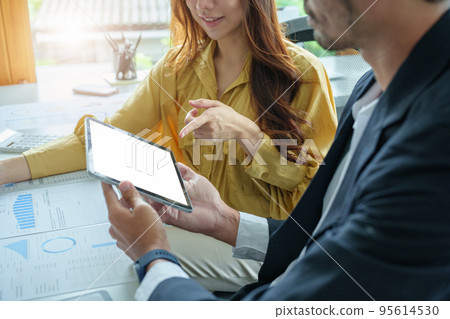 A portrait of a female business owner consulting a male salesperson to devise a strategy to increase revenue from new incoming goods using investment budget documents and an analytical computer. A portrait of a female business owner consulting a male salesperson to devise a strategy to increase revenue from new incoming goods using investment budget documents and an analytical computer. 95614530