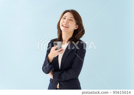 拿著智能手機藍色背景的婦女 拿著智能手機藍色背景的婦女 95615014