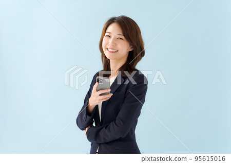 拿著智能手機藍色背景的婦女 拿著智能手機藍色背景的婦女 95615016