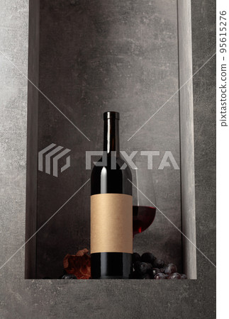 Bottle and glass of red wine with blue grapes. Bottle and glass of red wine with blue grapes. 95615276