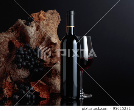 Bottle and glass of red wine. 95615281
