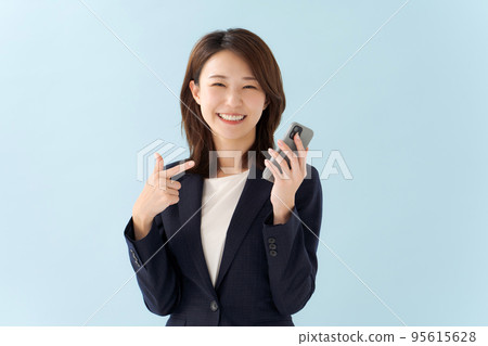 拿著智能手機藍色背景的婦女 95615628