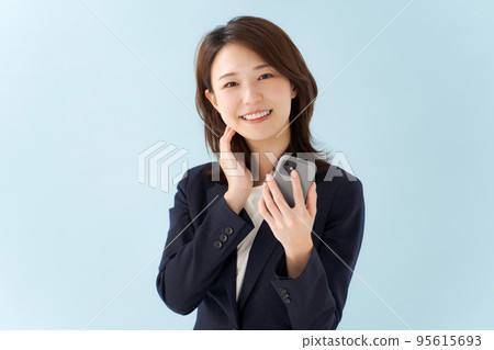 拿著智能手機藍色背景的婦女 拿著智能手機藍色背景的婦女 95615693