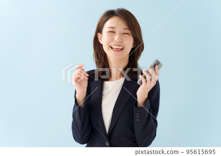 拿著智能手機藍色背景的婦女 拿著智能手機藍色背景的婦女 95615695