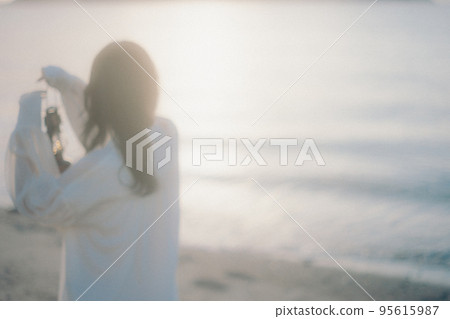 Photo of a woman standing by the beach Photo of a woman standing by the beach 95615987