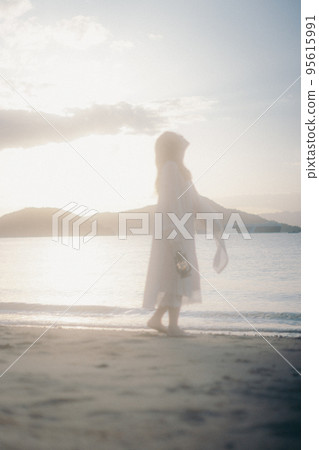 Photo of a woman standing by the beach 95615991