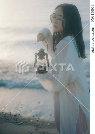 Photo of a woman standing by the beach 95616008