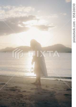 Photo of a woman standing by the beach 95616030