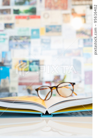 Open book with soft blurred reading glasses in background Open book with soft blurred reading glasses in background 95616402