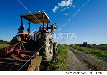 Blue sky, tractor and pasture 95617906