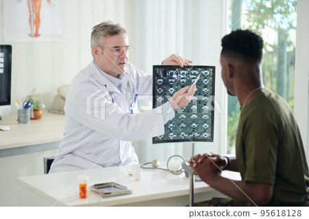 Emotional doctor talking to ex-soldier visiting clinic for annual checkup Emotional doctor talking to ex-soldier visiting clinic for annual checkup 95618128