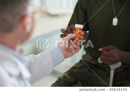 Closeup image of physician giving pills to military man Closeup image of physician giving pills to military man 95618134