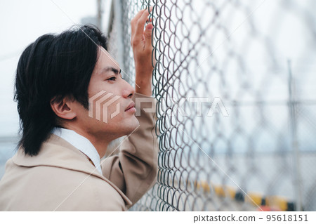 站在柵欄前的男人 95618151