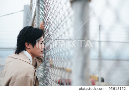 站在柵欄前的男人 95618152