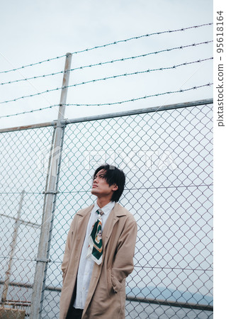 man standing in front of fence man standing in front of fence 95618164