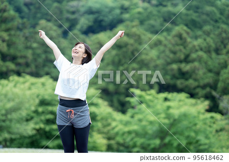 Young woman stretching in the fresh green Young woman stretching in the fresh green 95618462