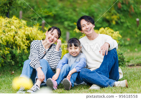 Close family sitting on the grass in the park 95618558