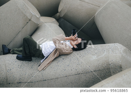 A man sitting on the breakwater and taking notes 95618865