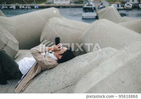 一個人坐在防波堤上做筆記 95618868