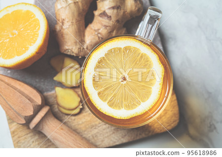 Ginger tea in glass mug. Winter vitamin drink for immunity boosting. Ginger tea in glass mug. Winter vitamin drink for immunity boosting. 95618986