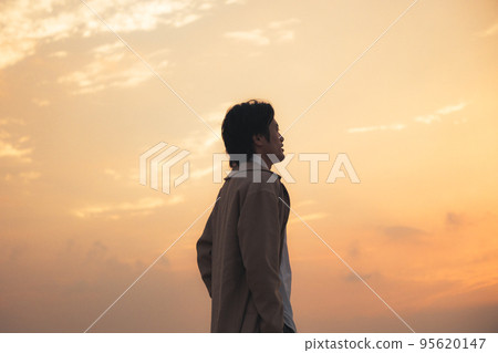 一個男人晚上在沙灘上看智能手機 一個男人晚上在沙灘上看智能手機 95620147
