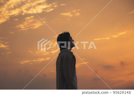 一個男人晚上在沙灘上看智能手機 一個男人晚上在沙灘上看智能手機 95620148