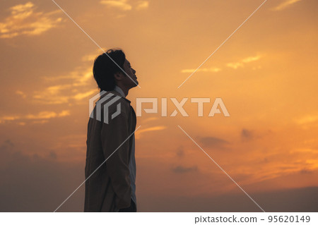 一個男人晚上在沙灘上看智能手機 一個男人晚上在沙灘上看智能手機 95620149