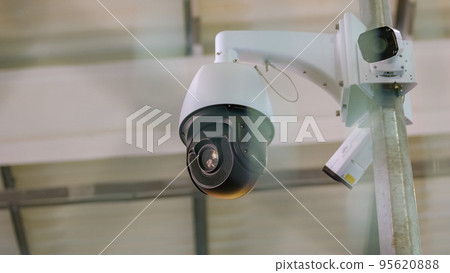 Black surveillance video camera turning to the right. Control camera rotation. 95620888