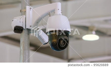 Rotating black surveillance control camera indoors. Public safety concept. 95620889