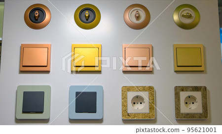 Close-up various sockets and switches on the white wall. Electrical equipment store. 95621001