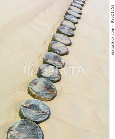 A wooden mall made of logs to protect the sandy beach on the sea. Summer vacation. A wooden mall made of logs to protect the sandy beach on the sea. Summer vacation. 95621352