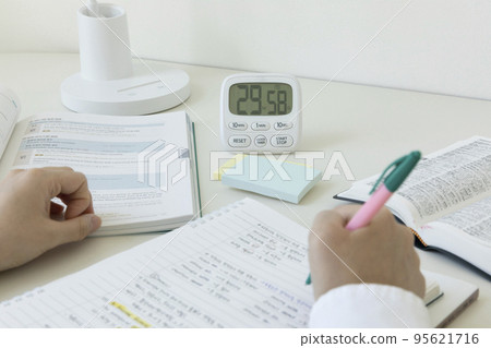 studying at home, study desk setup_studying while checking the time 95621716