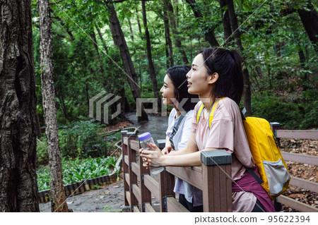 korean young women hiking and plogging_resting against the rail korean young women hiking and plogging_resting against the rail 95622394
