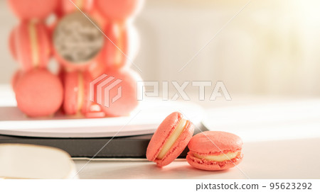 Pink macaron cake on round stand in the sun 95623292