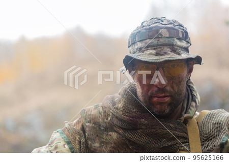 Portrait of a tired soldier with a dirty face. He looking at camera. Portrait of a tired soldier with a dirty face. He looking at camera. 95625166