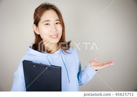 A woman holding a file and introducing a blank 95625751