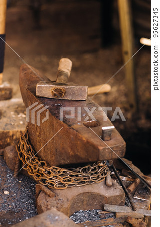 Forge, hammer on an anvil standing on the street 95627345
