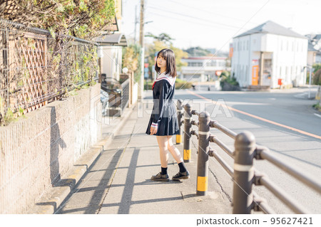 High school girl on her way home after school High school girl on her way home after school 95627421