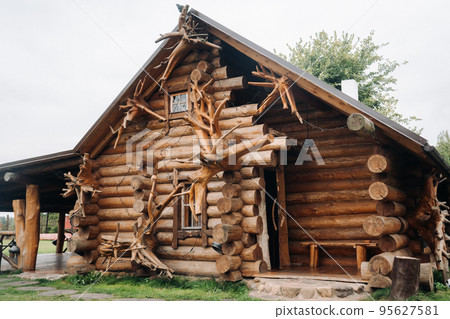 Beautiful carved wooden house in the village of logs and farmyards Beautiful carved wooden house in the village of logs and farmyards 95627581