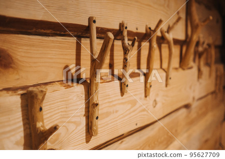 handmade wooden hangers are attached to the wall in a wooden house handmade wooden hangers are attached to the wall in a wooden house 95627709