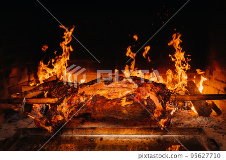 The lamb is cooked entirely on a spit on the fire. Cooking The lamb is cooked entirely on a spit on the fire. Cooking 95627710