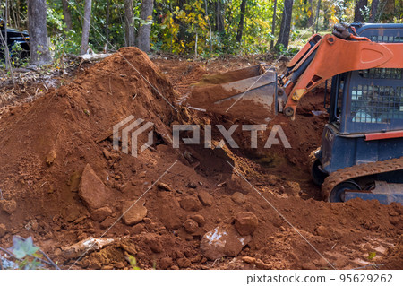 It is small tractor that is used for moving soil for landscaping purposes on construction site. 95629262